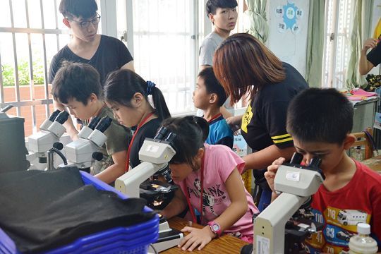醫技系同學教小朋友操作顯微鏡
Medical Lab Science & Biotech students teach children how to use microscopes.